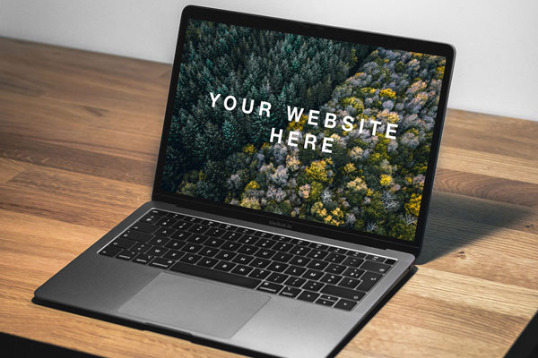 Mockup Featuring 3/4 view a Macbook Air facing light on a Desk FREE PSD