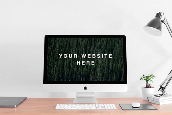 Mockup Featuring Realistic iMac on a Desk Next to a Lamp and a Plant FREE PSD