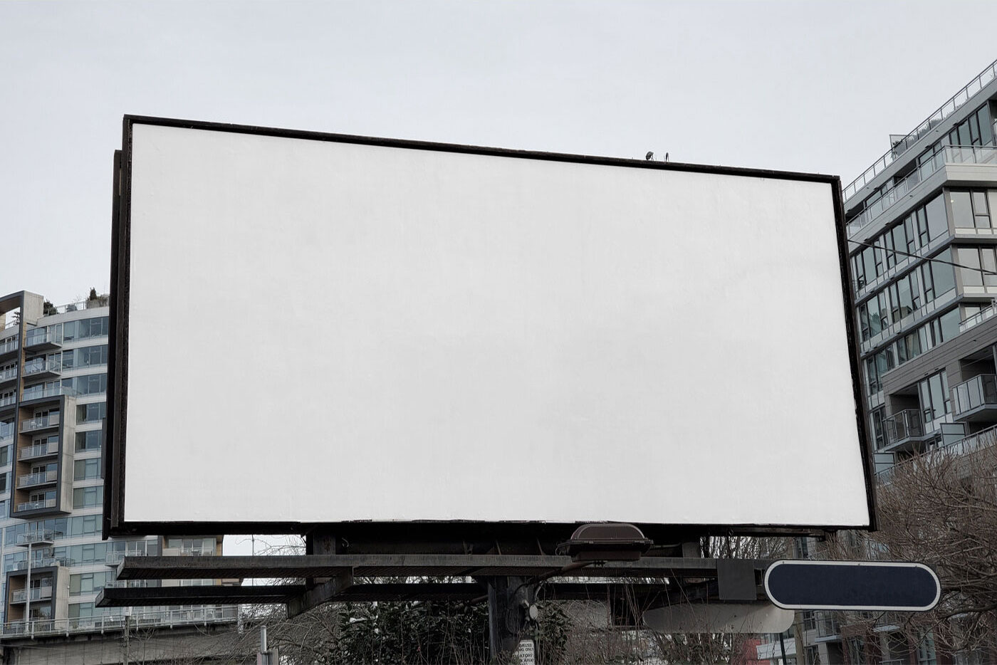 Front View of a City Billboard in front of Modern Buildings FREE PSD