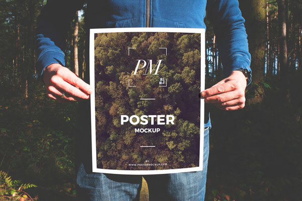 Man Holding a Nature-oriented Poster Mockup FREE PSD
