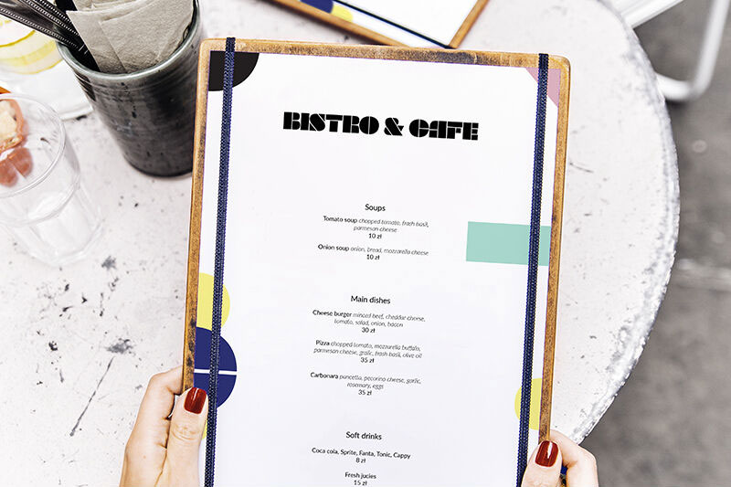 Mockup Featuring Hand Holding Restaurant Menu with a Table at Background  (FREE) - Resource Boy