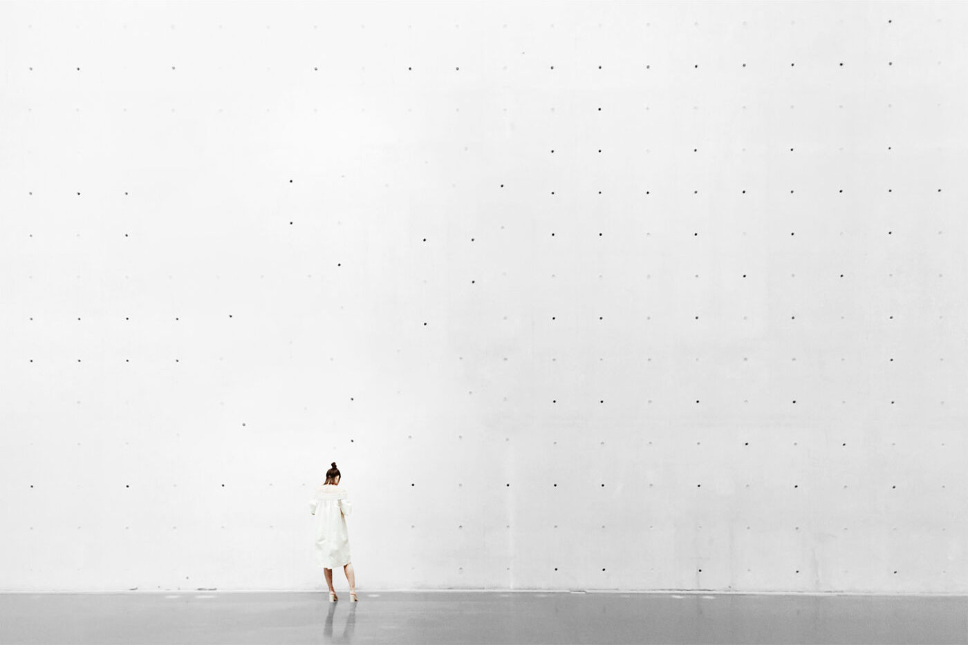 Concrete Wall Mockup Featuring a Woman from Back View FREE PSD