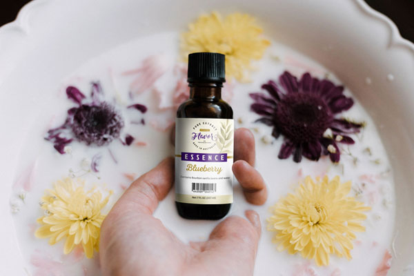 Hand Holding Food Essence Bottle with Milk and Flower around Mockup FREE PSD