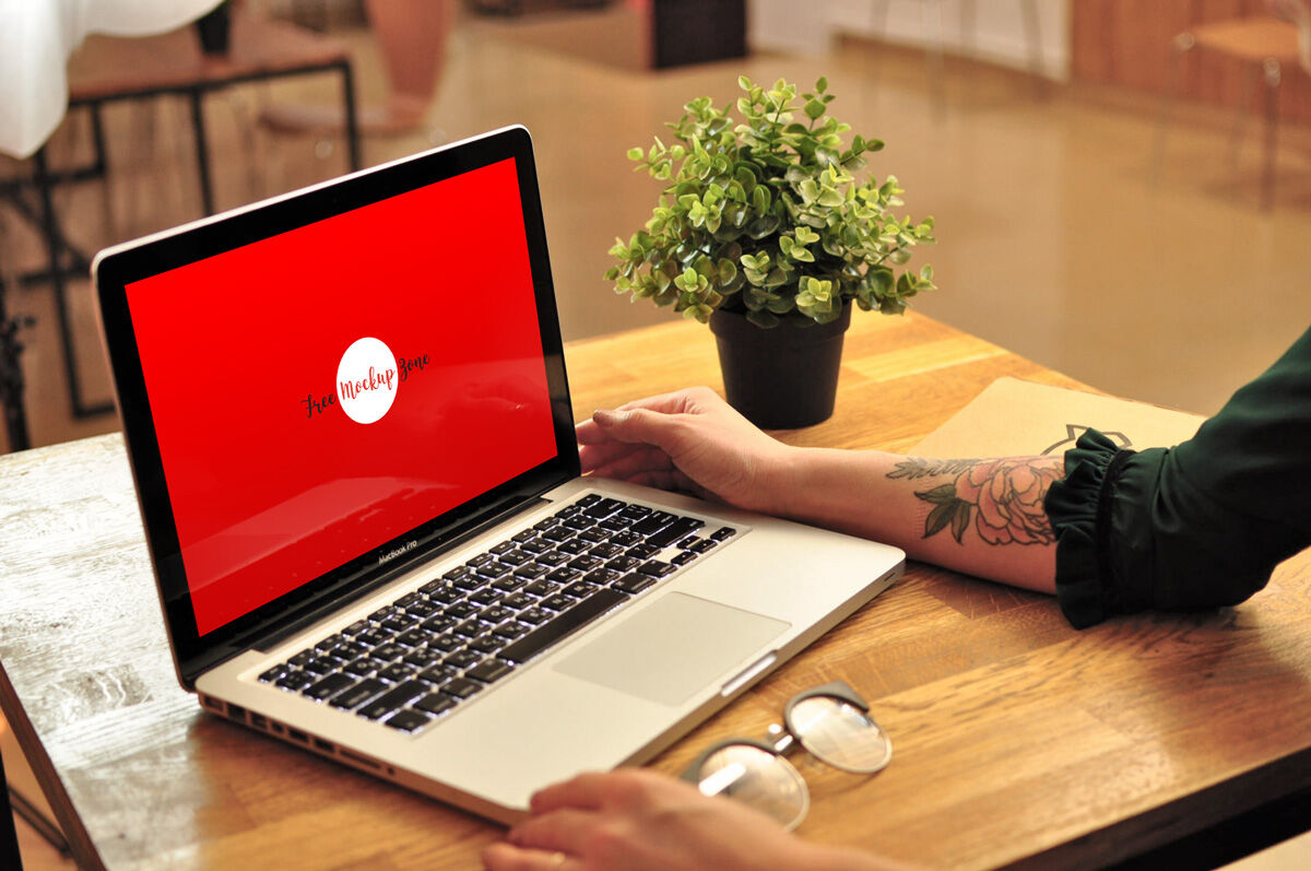 MacBook Pro on Wooden Table in a Cafe Perspective View Mockup FREE PSD