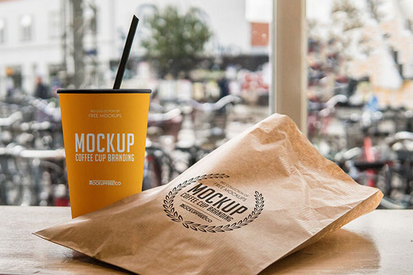 Mockup Featuring Coffee Cup and Paper Bag on Wooden Table FREE PSD