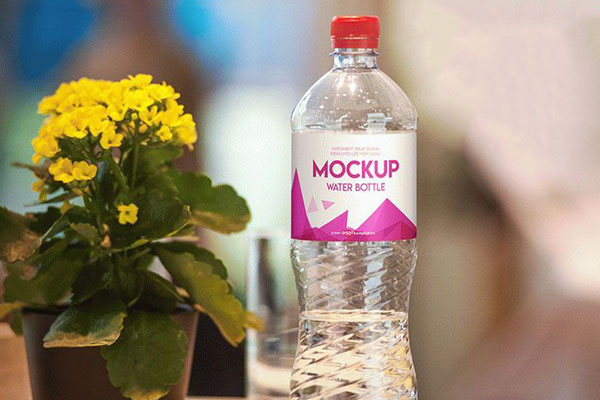Water Bottle Label Mockup Next to a Flower FREE PSD