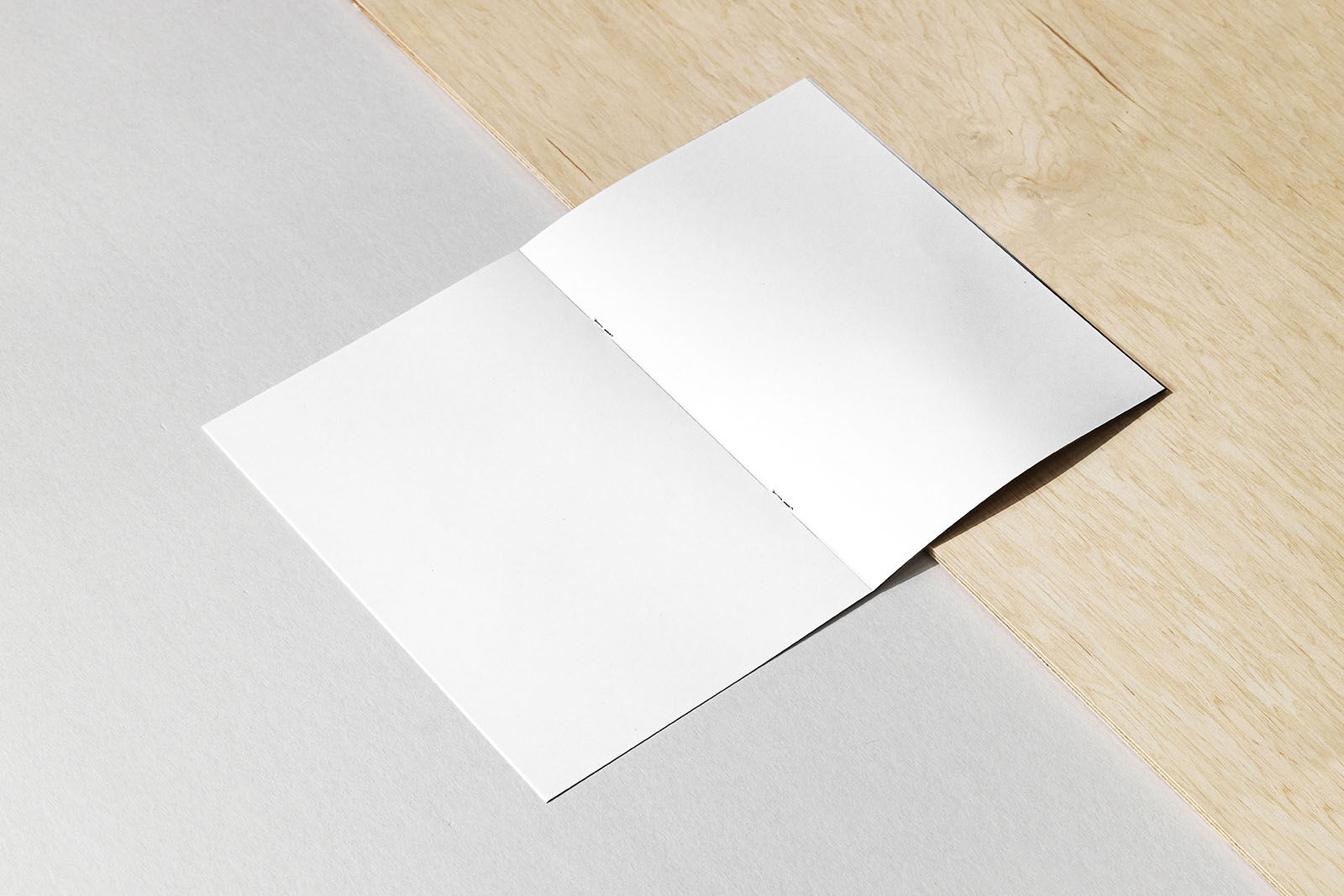 A4 Saddle Stitched Brochure Mockup with Wooden Background FREE PSD