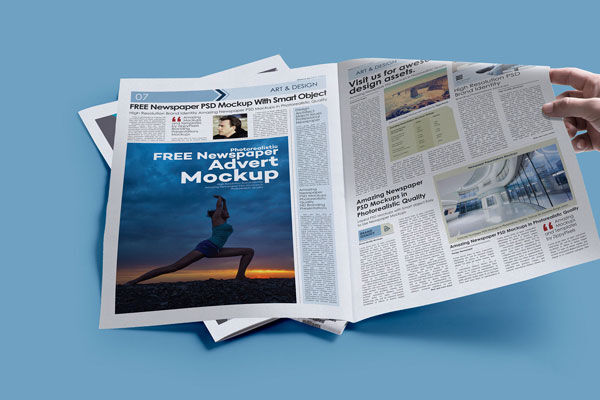 Hand Holding Opened Newspaper Laid On The Ground Mockup (FREE