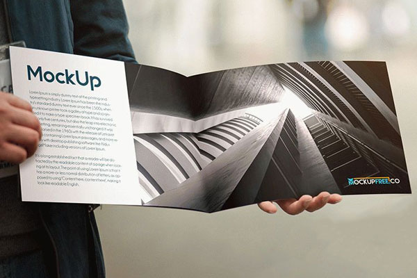 Two Mockups Featuring Man Holding Opened and Closed Booklets FREE PSD