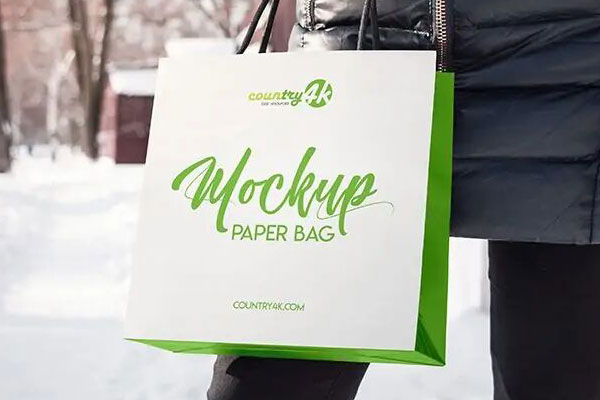 3/4 View of a Paper Bag Held Up by a Hand Mockup FREE PSD