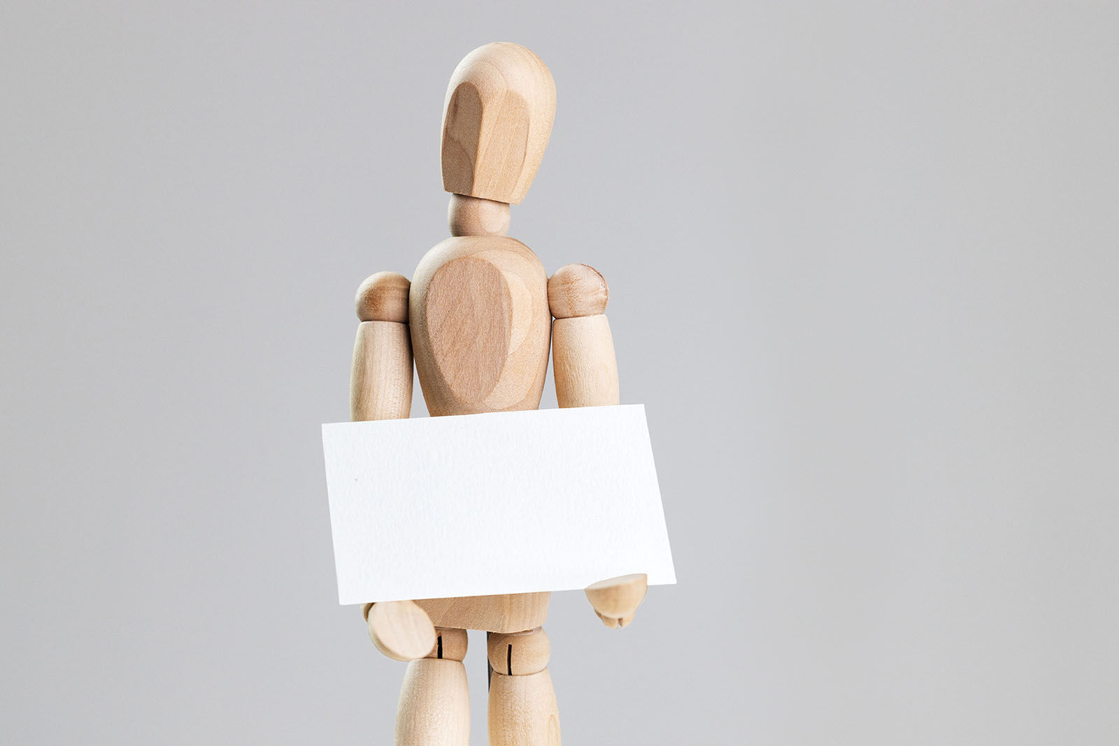 Business Card Held in Hands of a Wooden Manikin Mockup FREE PSD