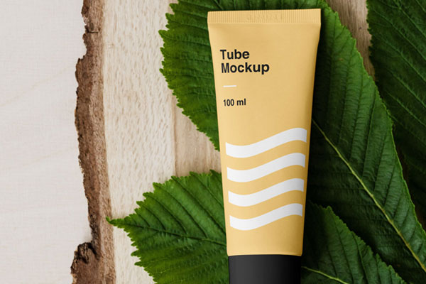 A Cosmetic Tube on Bunch of Leaves and a Piece of Wood Mockup FREE PSD