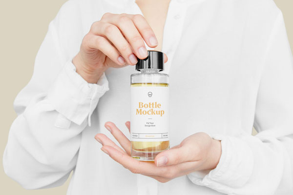 Front View of Hand Holding Plastic Bottle Mockup FREE PSD