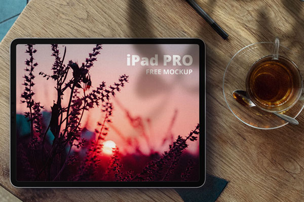 iPad Pro Next to a Cup of Tea on a Wooden Desk Mockup FREE PSD