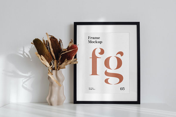 Simple Frame on the Desk Mockup Next to a Flower FREE PSD