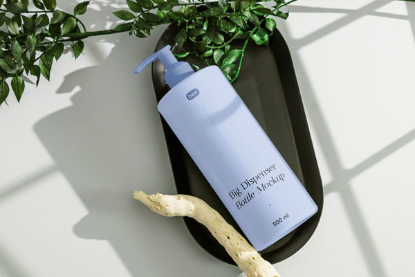 Top View of Realistic Lying Dispenser Bottle Mockup with Plant FREE PSD