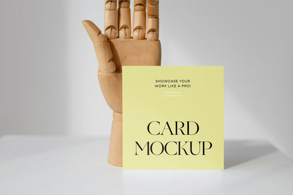 Front View of a Standing Card Mockup with a Wooden Hand FREE PSD