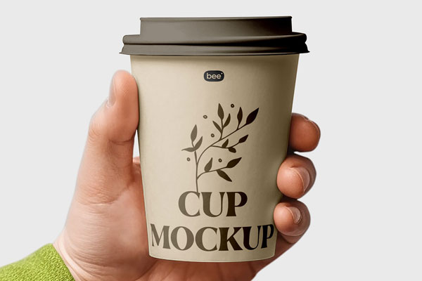 Facing View of Medium Paper Cup Mockup in Hand FREE PSD
