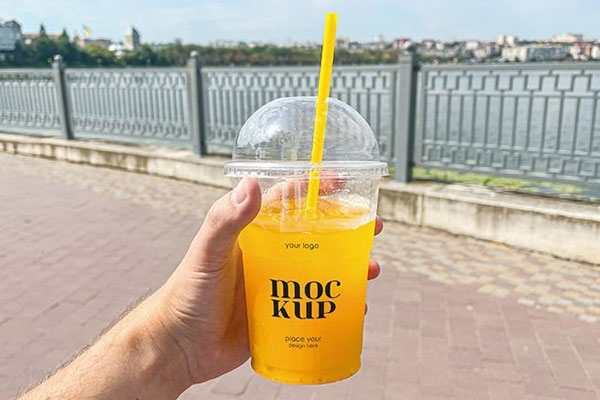 Facing Vision of Plastic Juice Cup Mockup in Hand FREE PSD