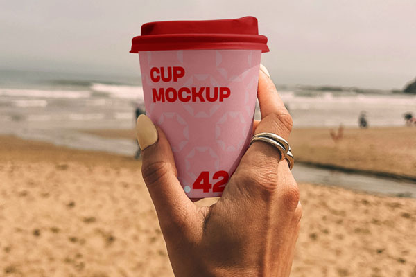 Free Paper Coffee Cup on the Beach Mockup PSD Template