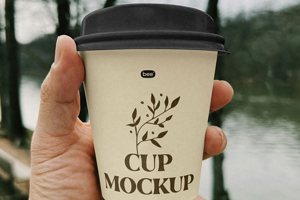 Free Small Paper Cup in Hand Mockup PSD Template