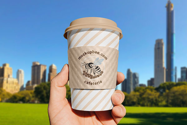 Free Paper Cup Sleeve in Hand Mockup PSD Template