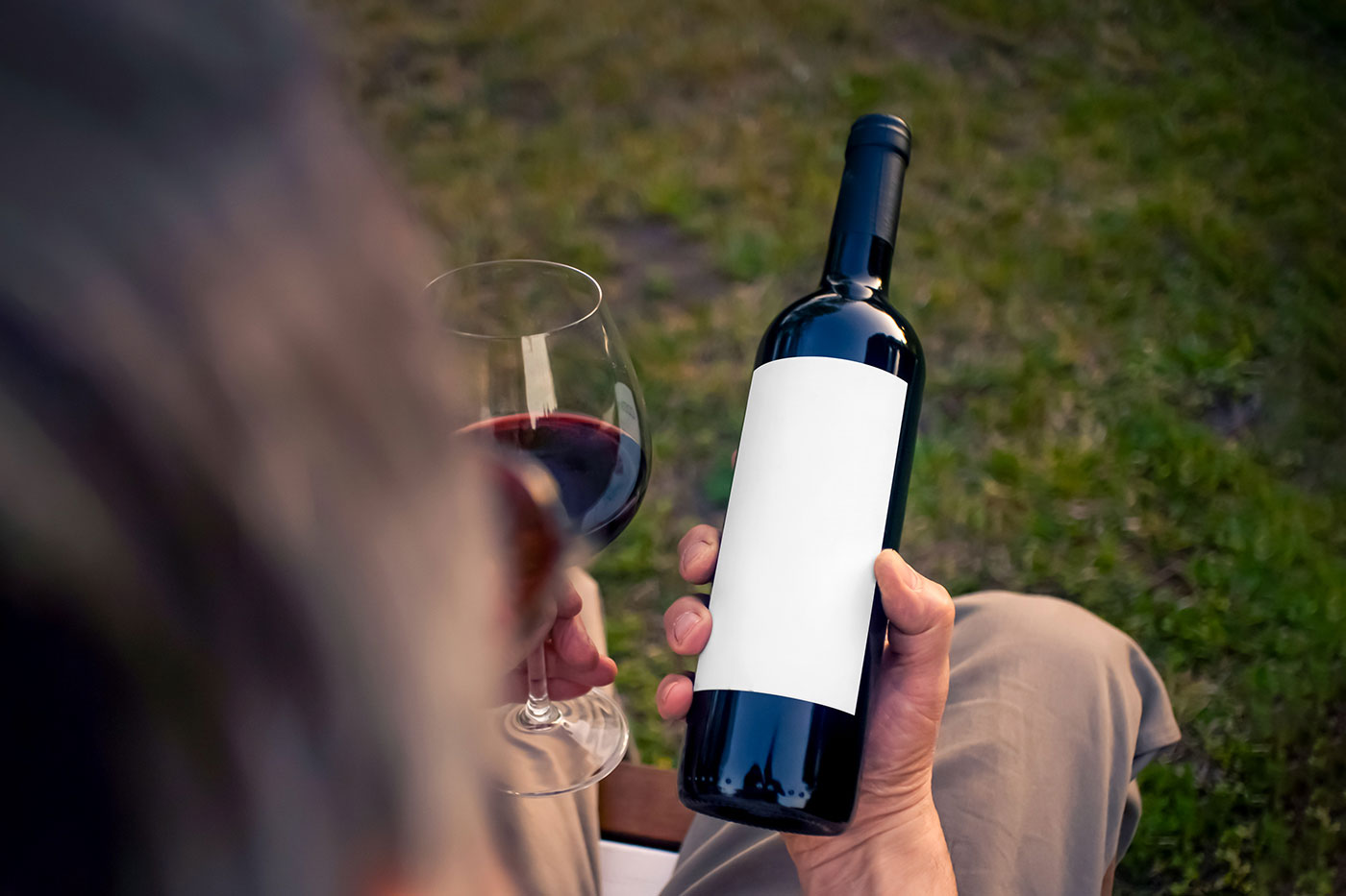 Free Wine Bottle in Hand Mockup PSD Template