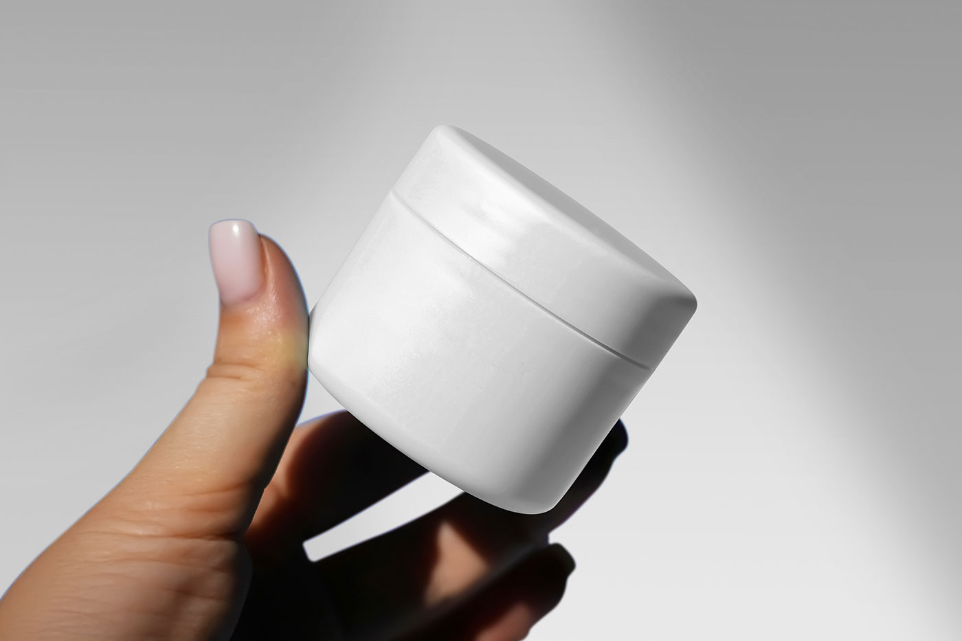 Free Cosmetic Jar in Hand Mockup PSD Template