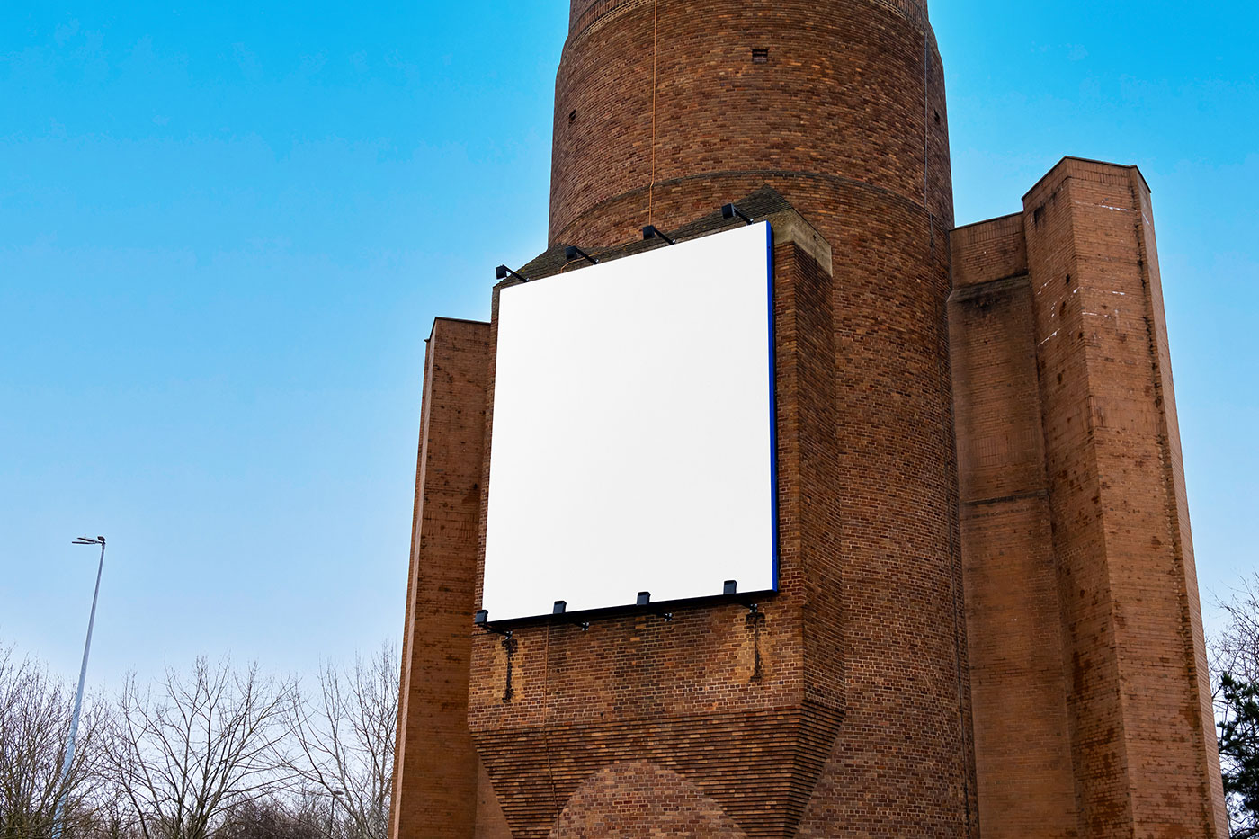 Free Billboard on Brick Building Mockup PSD Template