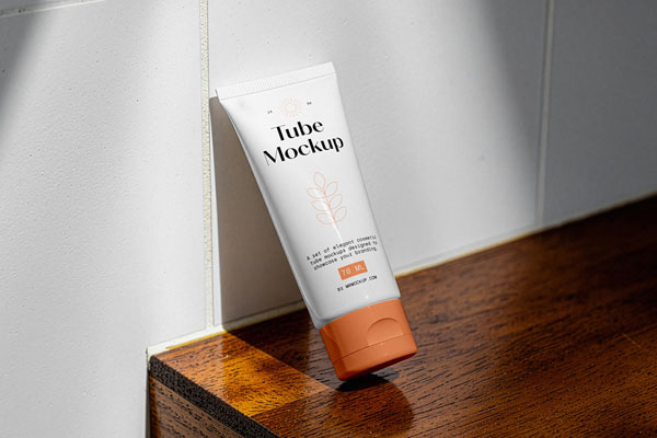 Free Cosmetic Tube Leans Against Wall Mockup PSD Template