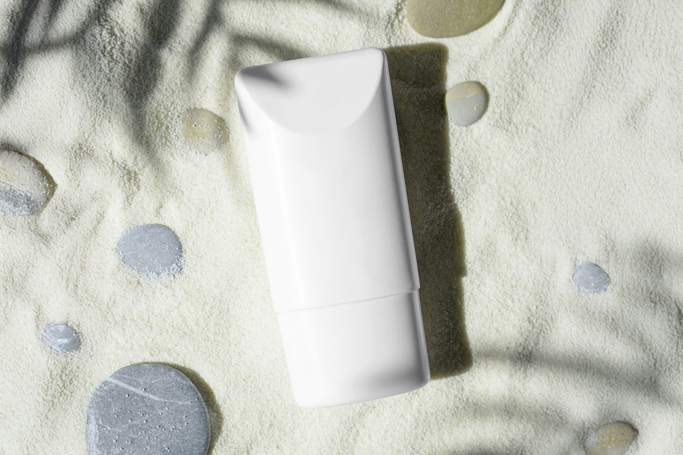 Free Cosmetic Bottle on Sand Mockup PSD Template