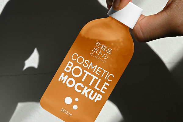 Free Cosmetic Glass Bottle in Hand Mockup PSD Template