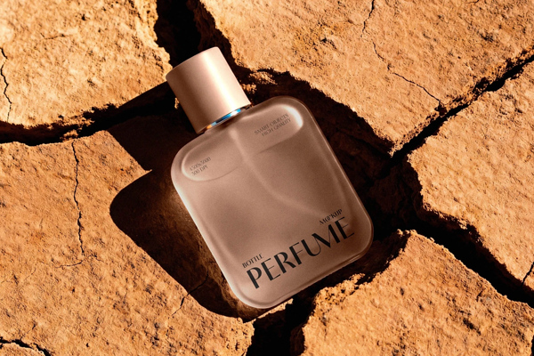 Free Glass Perfume Bottle Mockup in Sand PSD Template