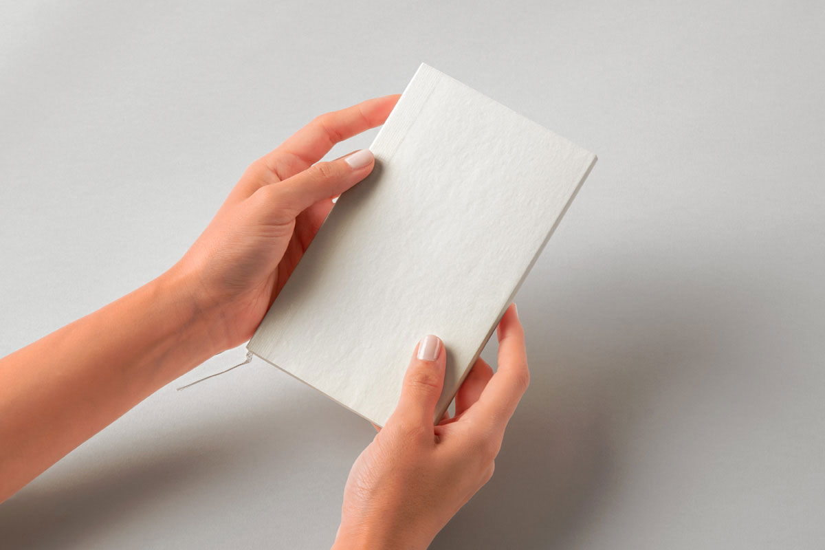 Free Hand Holding Cotton Notebook Mockup PSD Template