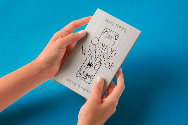 Free Hand Holding Cotton Notebook Mockup PSD Template