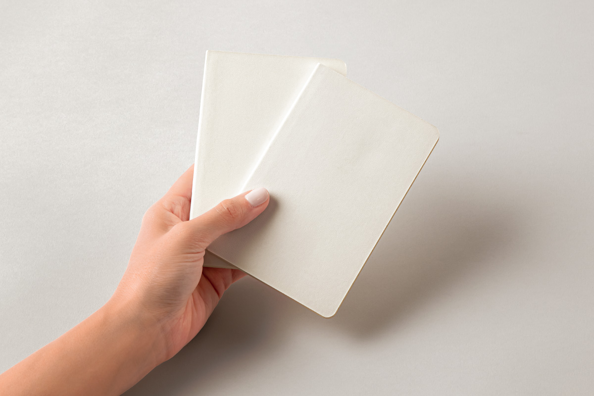 Free Hand Holding Pocket Notebooks Mockup PSD Template