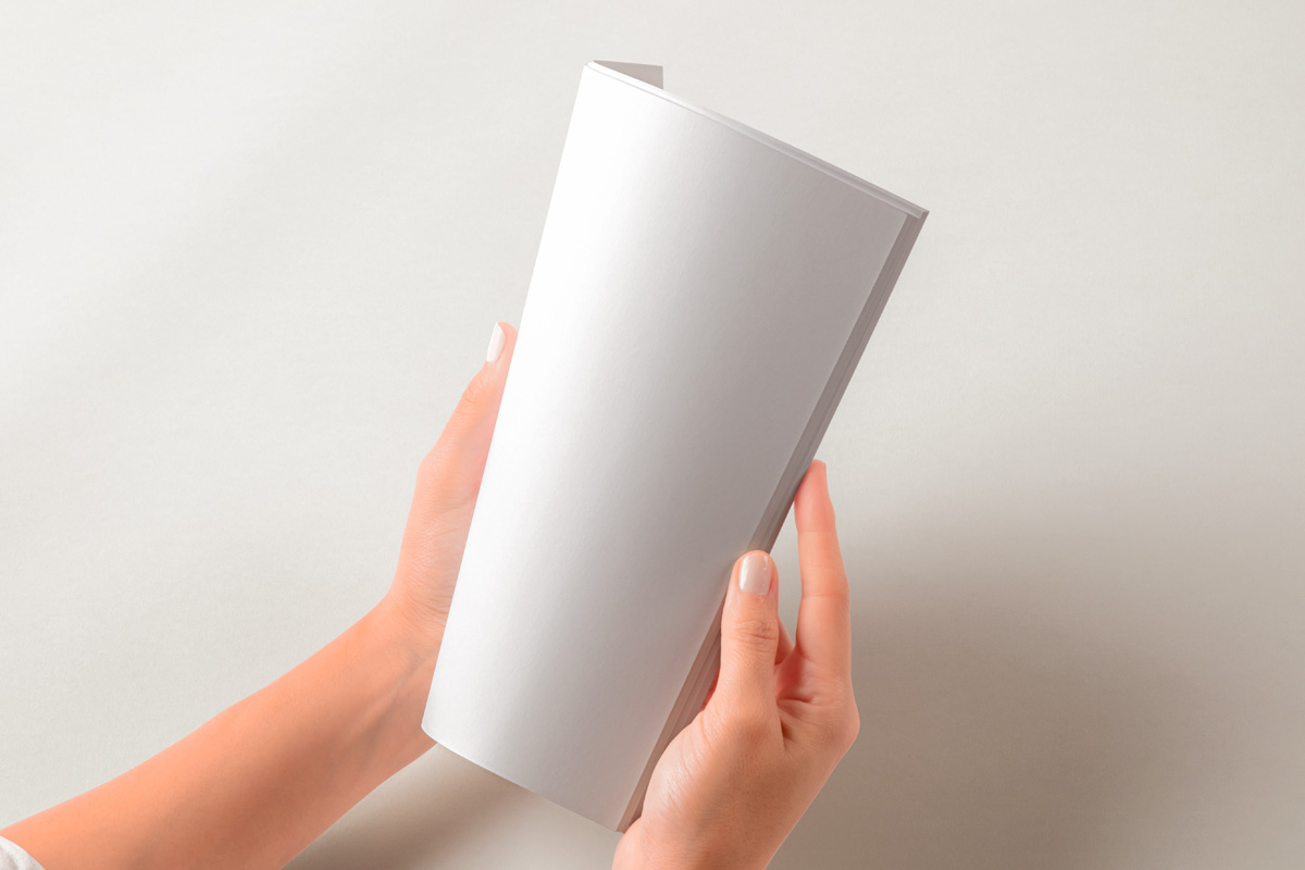 Free Hands Holding Folded Magazine Mockup PSD Template