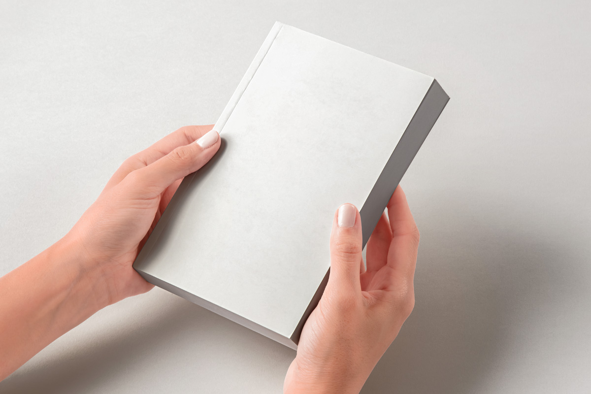Free Hands Holding Paperback Book Mockup PSD Template