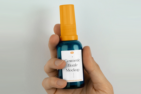 Free Small Spray Bottle in Hand Mockup PSD Template