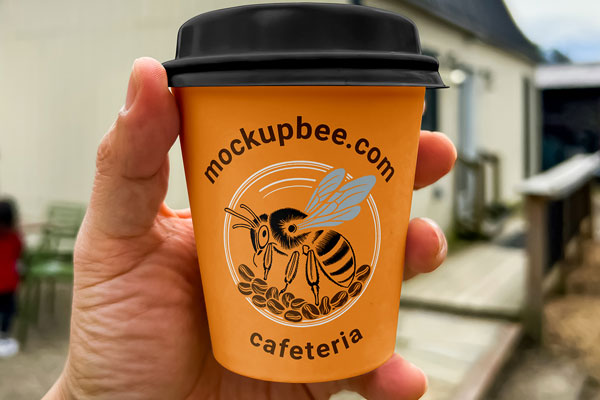 Free Small Coffee Cup in Hand Mockup PSD Template
