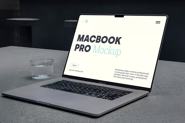 Free MacBook Pro Laying on Concrete Mockup PSD Template